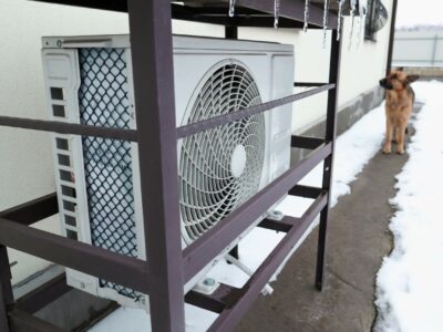 A heat pump unit outside a house in the winter